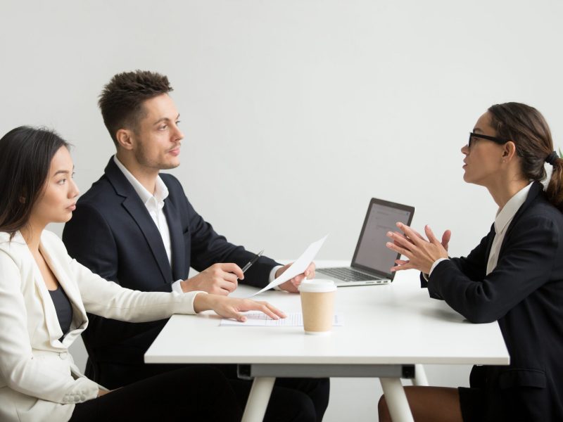 Female job applicant interviewed by two HR managers reading her resume, employee talking about experience, sharing thoughts during recruitment process. Concept of hiring, employment, cooperation